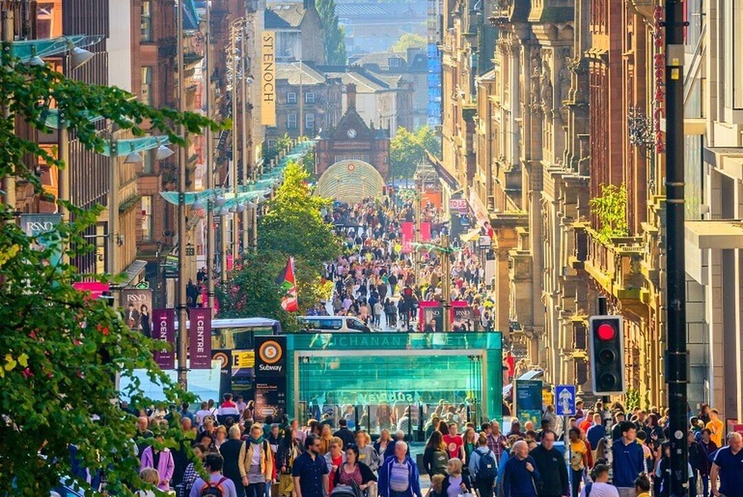 A bustling Buchanan Street, Glasgow's main pedestrianised shopping area, with lots of people and buildings on either side.