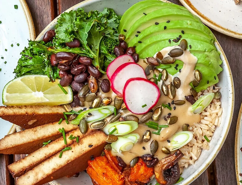 A plate of colourful food including the likes of green avocado, red raddishes and brown beans.