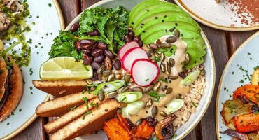 A plate of colourful food including the likes of green avocado, red raddishes and brown beans.