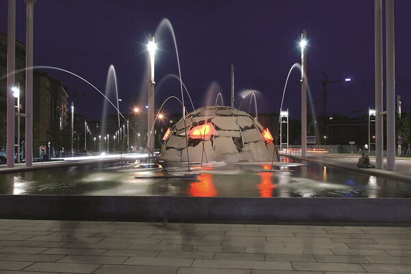 Merz Fountain in Torino at night with red and white lights.