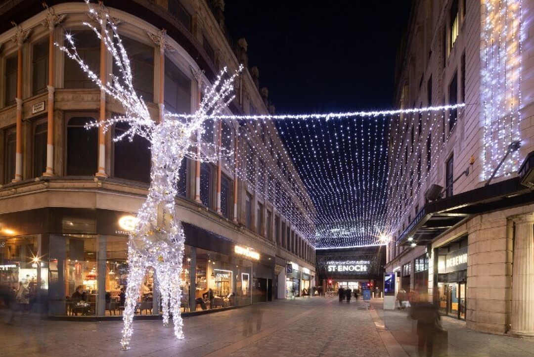 A larger than life light up reindeer stands in front of a canopy of lights at the entrance to the St. Enoch Centre