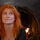 Eddi Reader with her trademark red hair looks up away from the camera against a night time sky.
