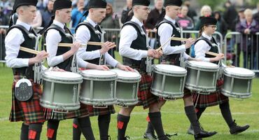 6 people in traditional Scottish dress with drums.