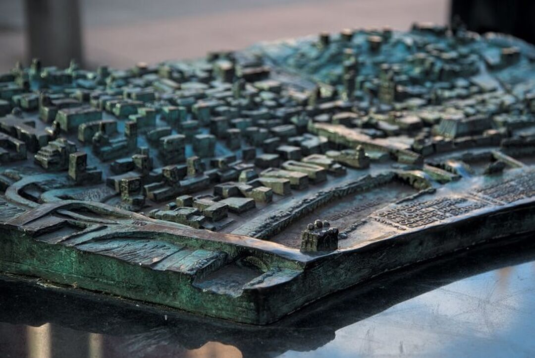 A bronze 3D map of Glasgow city centre with grooves and peaks representing roads, buildings and rivers.