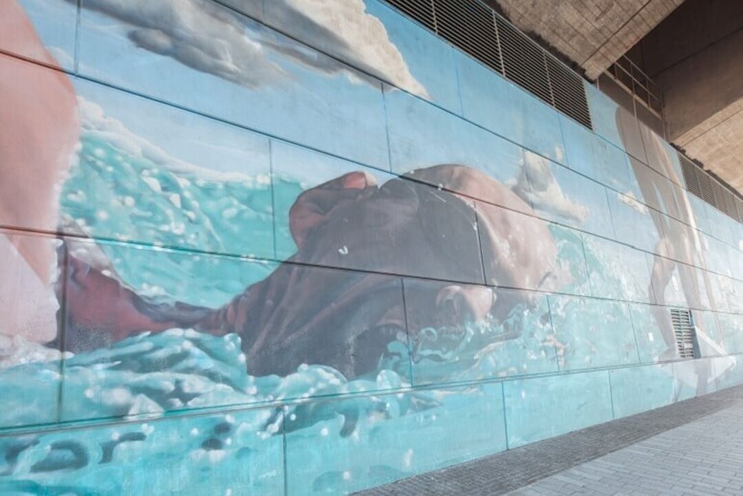 A close up image of The Swimmer mural, showing someone swimming in open water with goggles on.