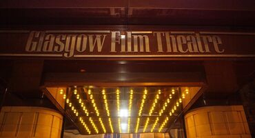 The entrance to the Glasgow Film Theatre with signage of the name and a canopy of lights below.