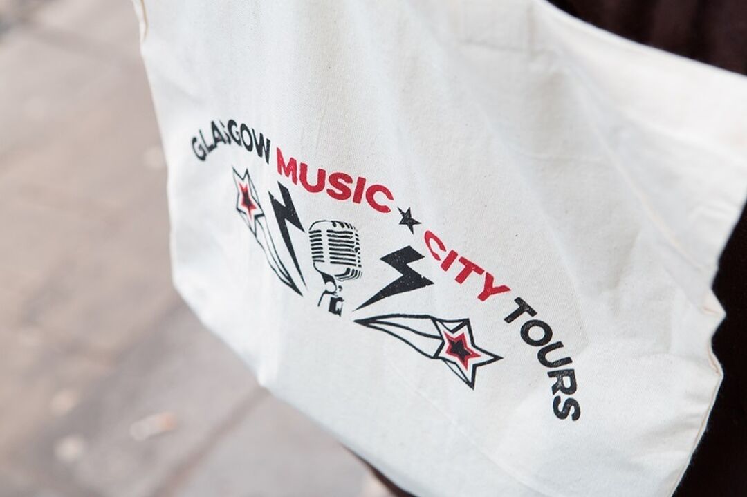 A tote bag which reads 'Glasgow Music City Tours' in red and black text.