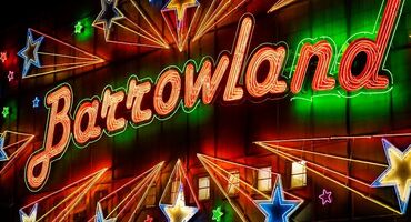 The famous neon sign of music venue Barrowland is lit up red. Neon stars surround the name of the venue.