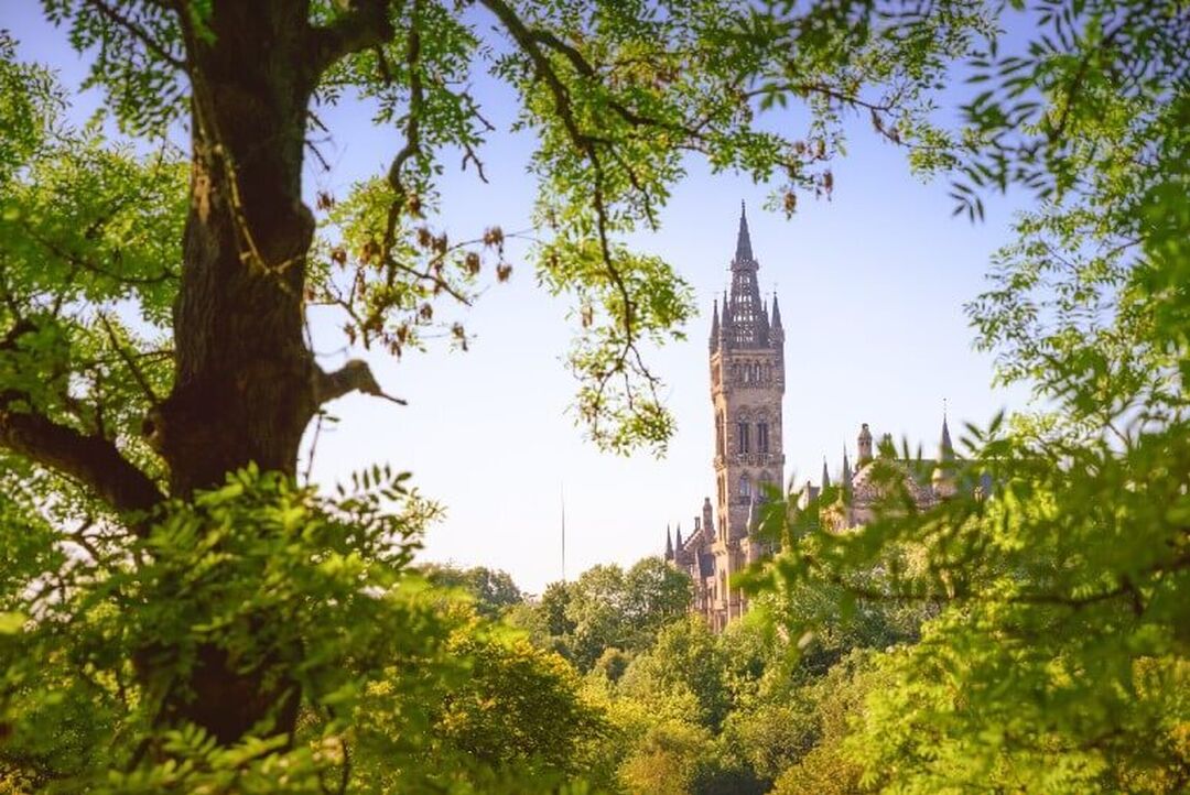 The grand spire of the University of Glasgow can be seen appearing between trees on all sides.